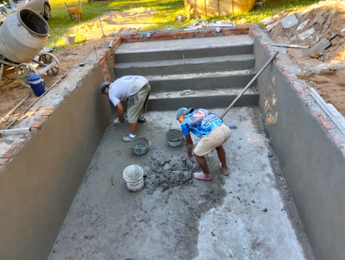 Equipo trabajando en el revoque de una piscina